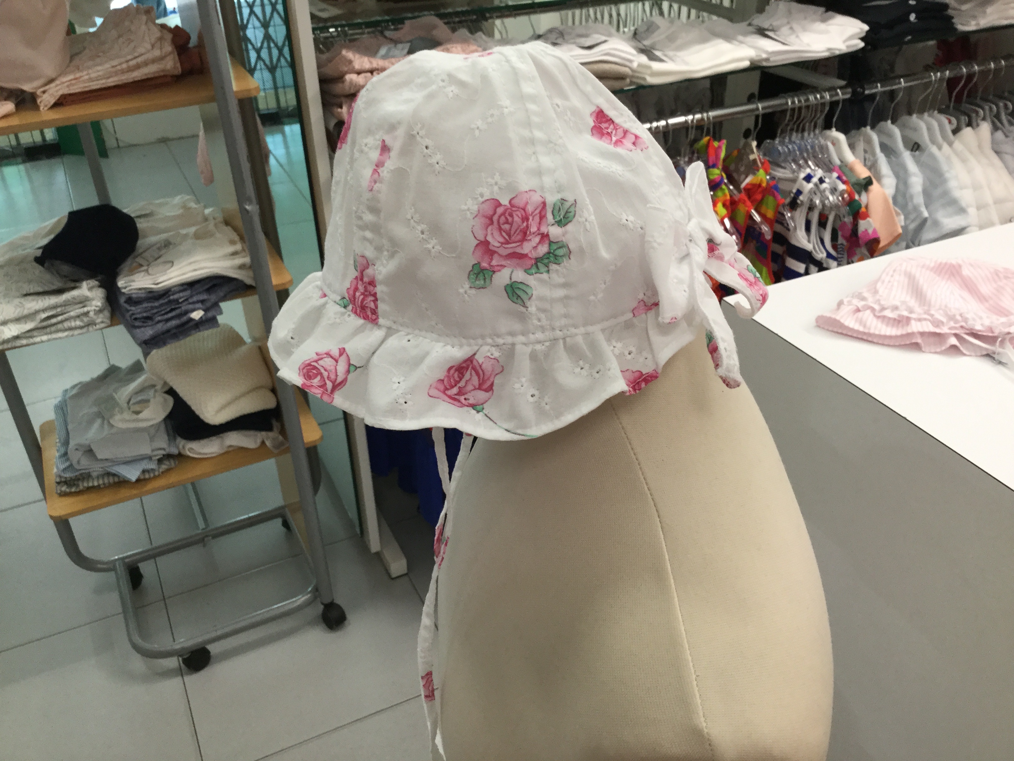 Cappello bianco con fiori e fiocchetto dietro 